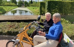 Twee duofietsers op een duofiets in de natuur